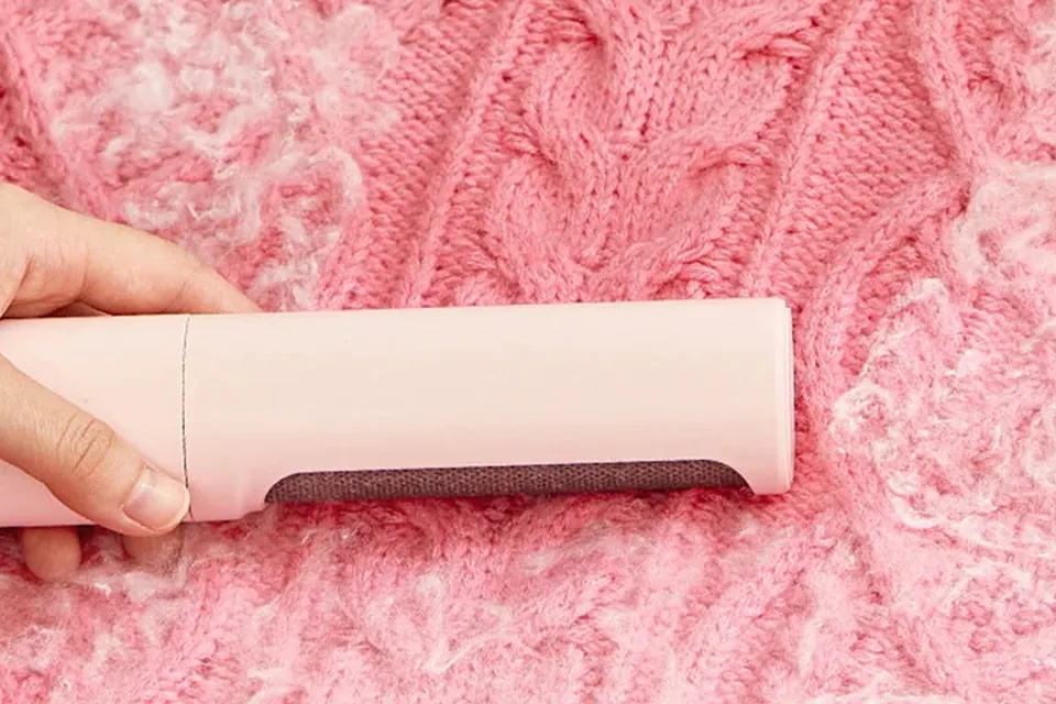 Self-Cleaning Pet Hair Remover Duo brushing loose hair from a soft fabric surface